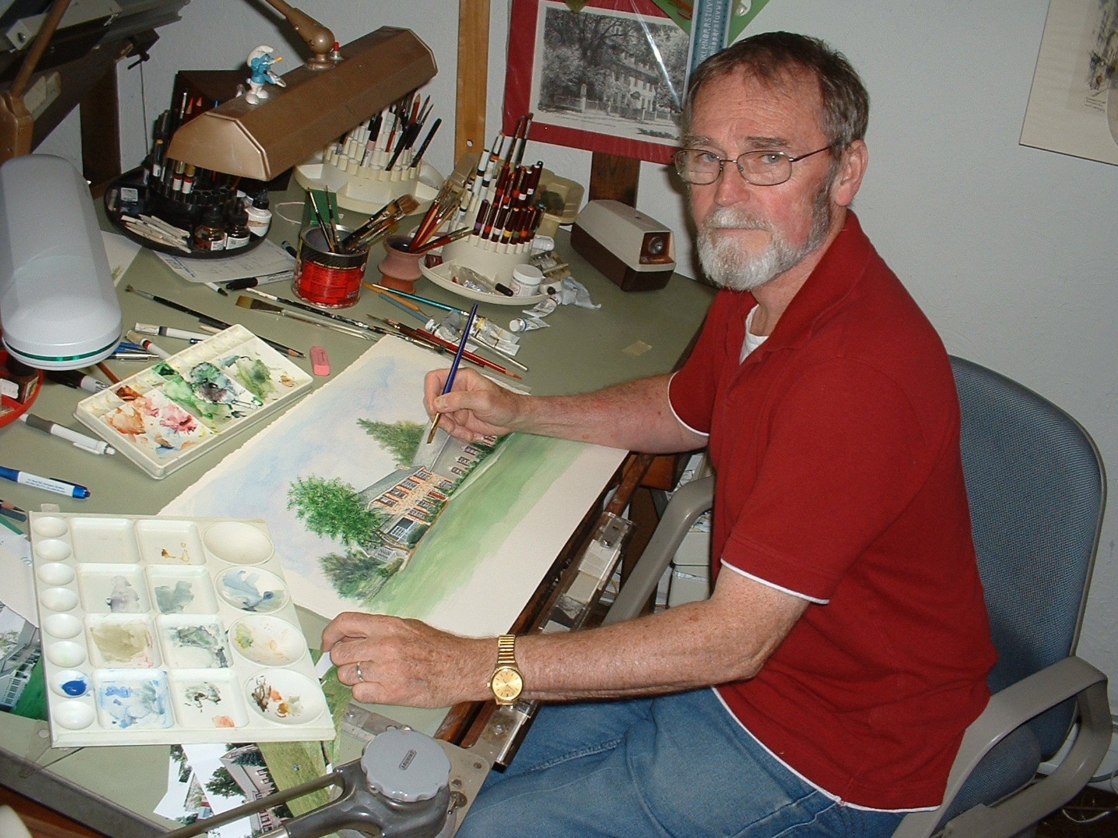 Photo of artist Joe Sebes sitting at his drawing table working on a house portrait